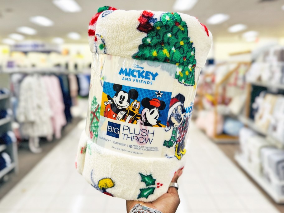 hand holding up a disney christmas print throw blanket