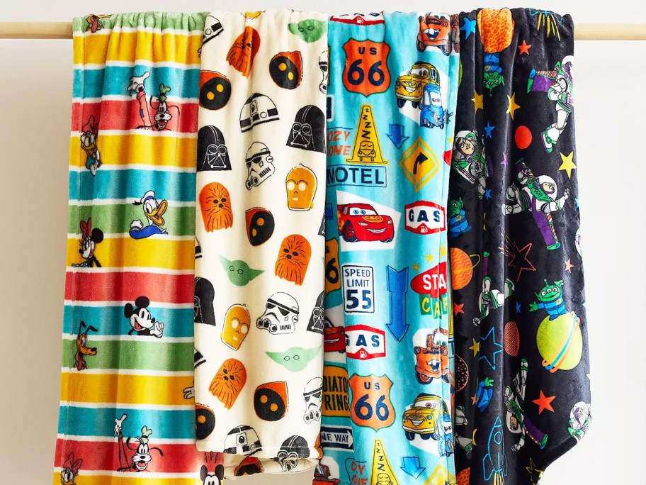 disney print throw blankets draped over a wooden rod