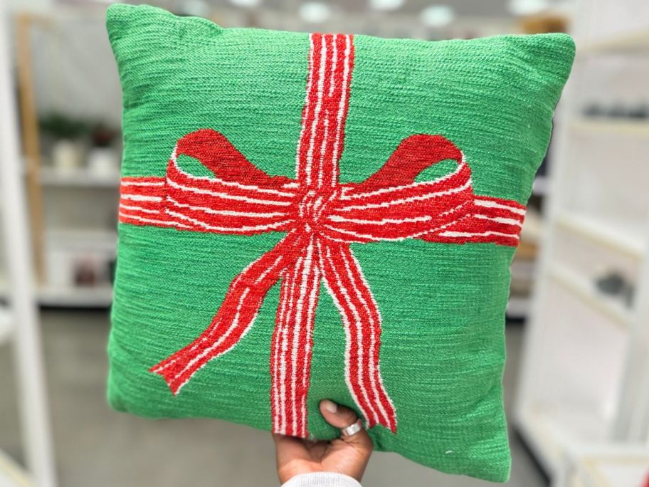 Hand holding up a Threshold Woven Square Throw Pillow that looks like a Present