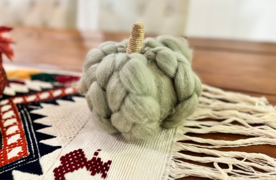 A green fabric pumpkin from Walmart displayed as fall decor on a dining table