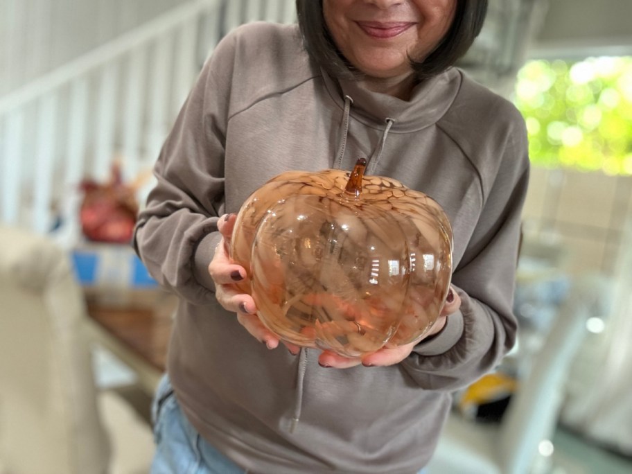 woman holding an orange marble pumpkin from walmart