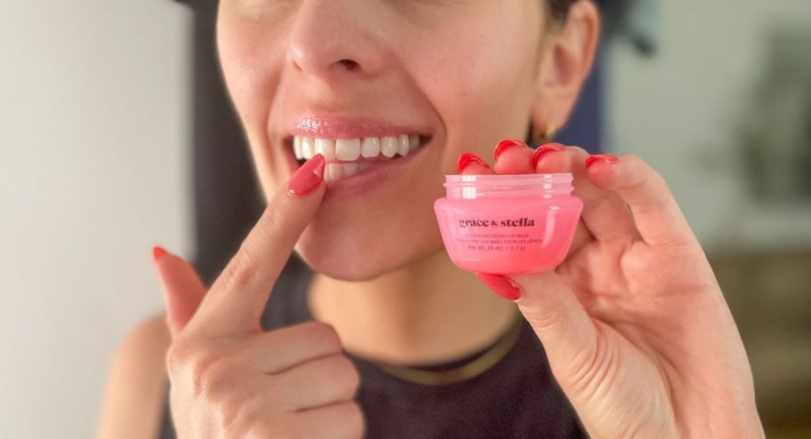 Woman applying lip mask with finger