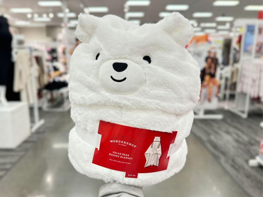 a womans hand holding a wearable polar bear hooded blanket