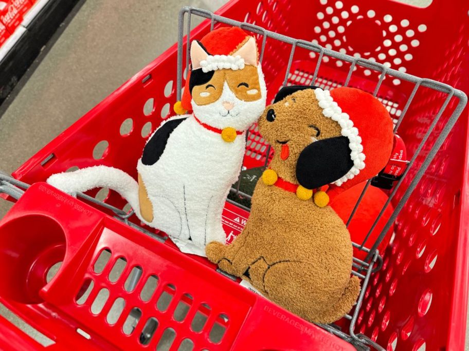  cat and dog-shaped holiday throw pillows in a red shopping cart