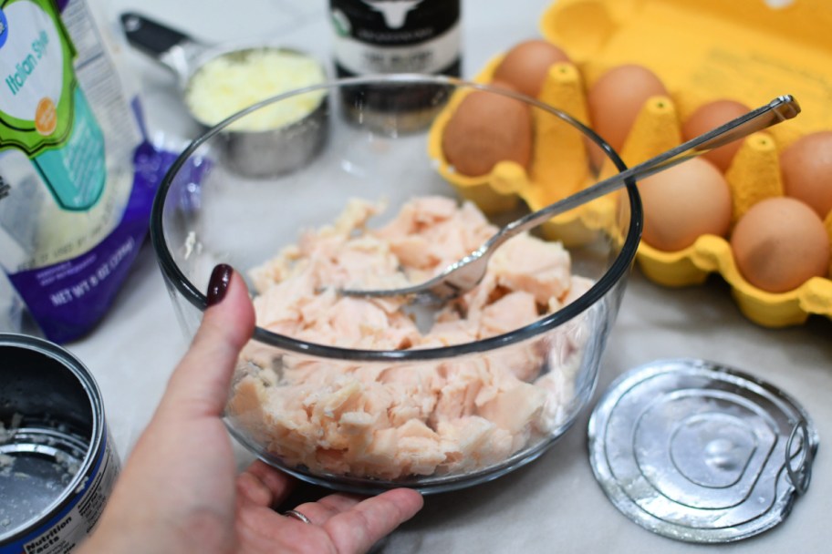 adding canned chicken to a mixing bowl 