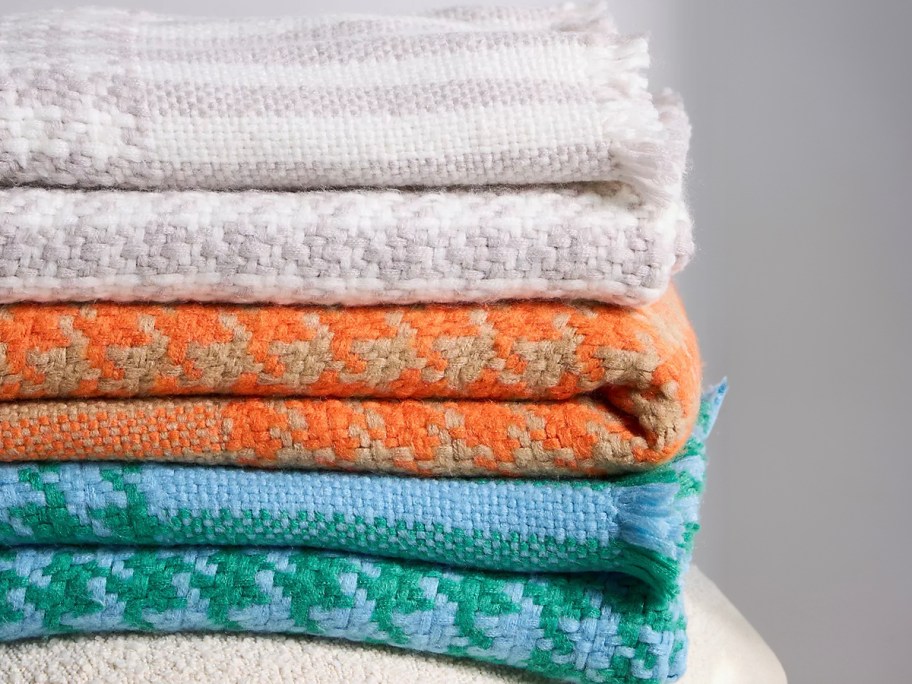 stack of anthropologie blankets 