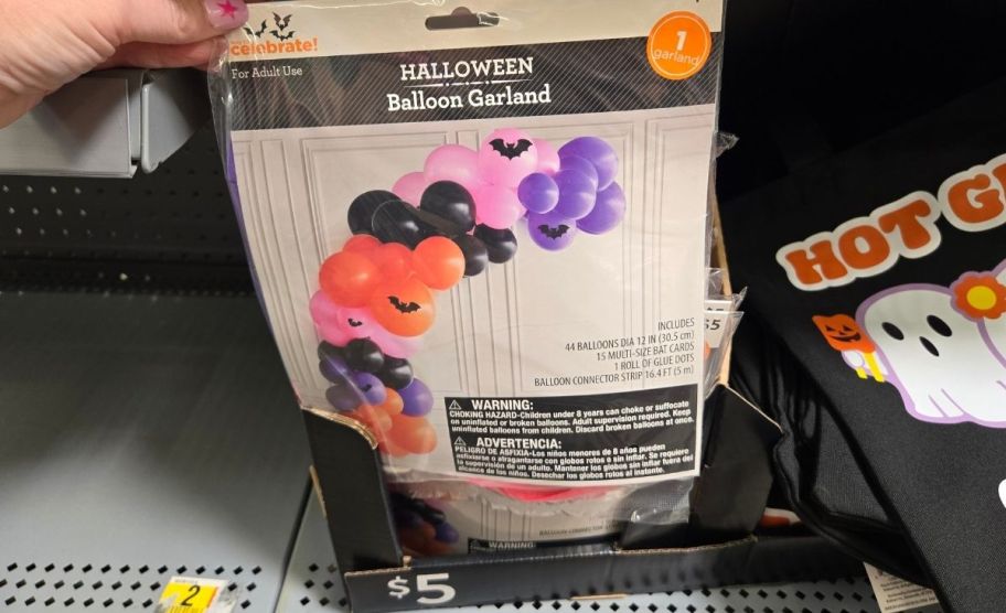 a woman's hand holding a balloon garland package