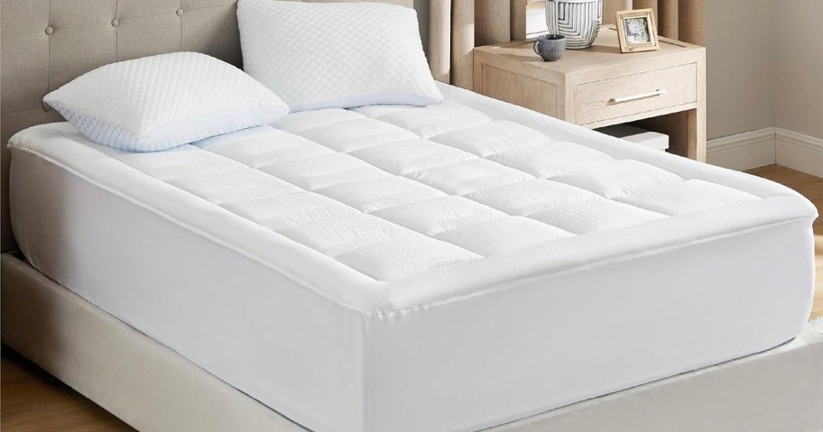 white mattress pad with pillows on bed 