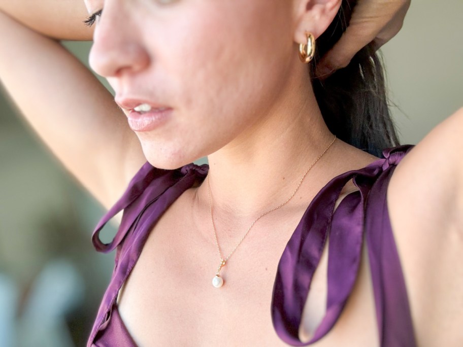 woman in purple dress wearing pearl necklace