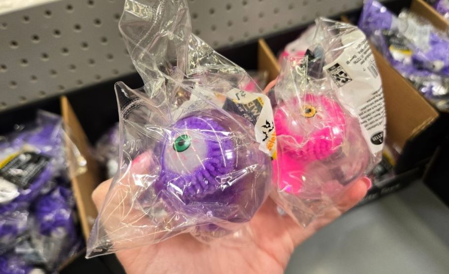 a woman's hand holding two neon eyeballs