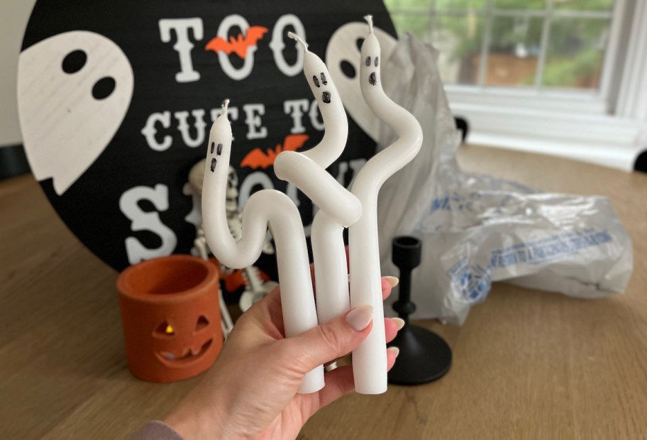 hand holding diy ghost taper candles