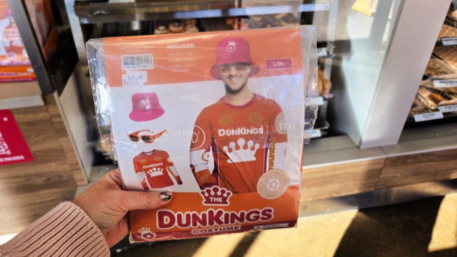 hand holding a dunkings halloween costume in the package in a dunkin store