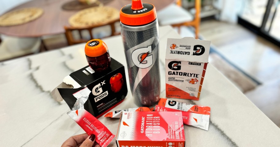Gatorade plastic water bottle with a personalized lid next to Gatorade pods, tablets, and packets on a kitchen counter