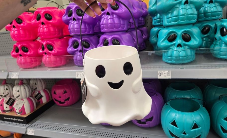 a woman's hand holding a ghost treat pail