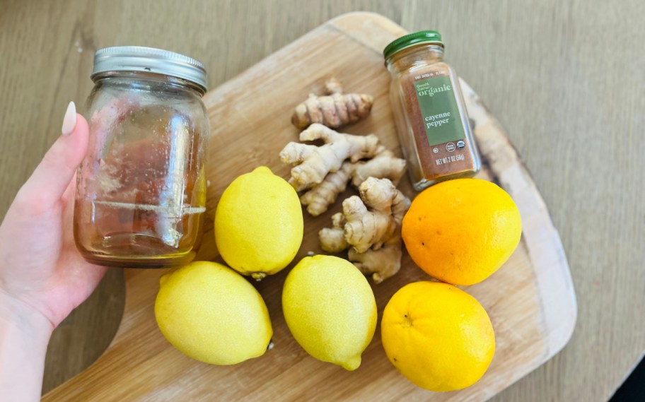 ginger turmeric shots ingredients on wood cutting board