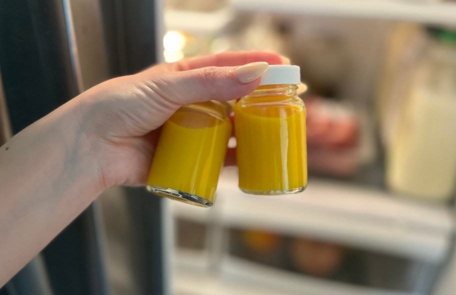 hand holding two ginger turmeric shots