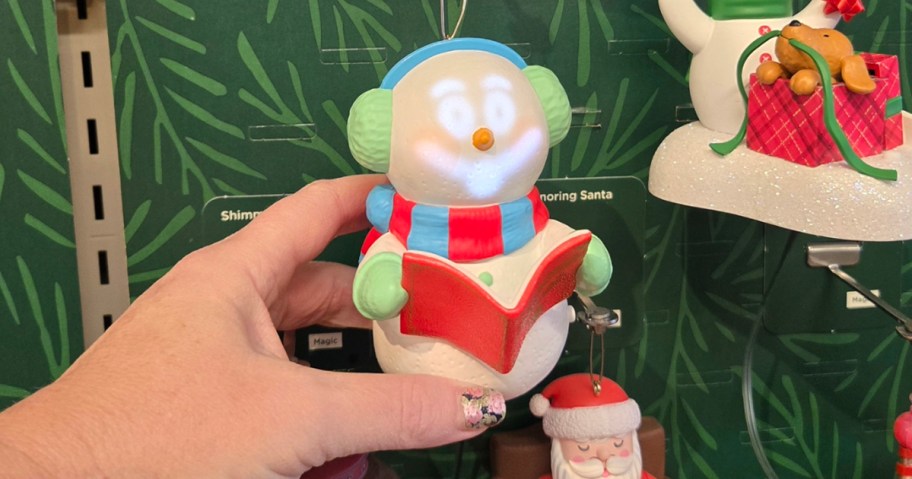 hand holding caroling snowman ornament