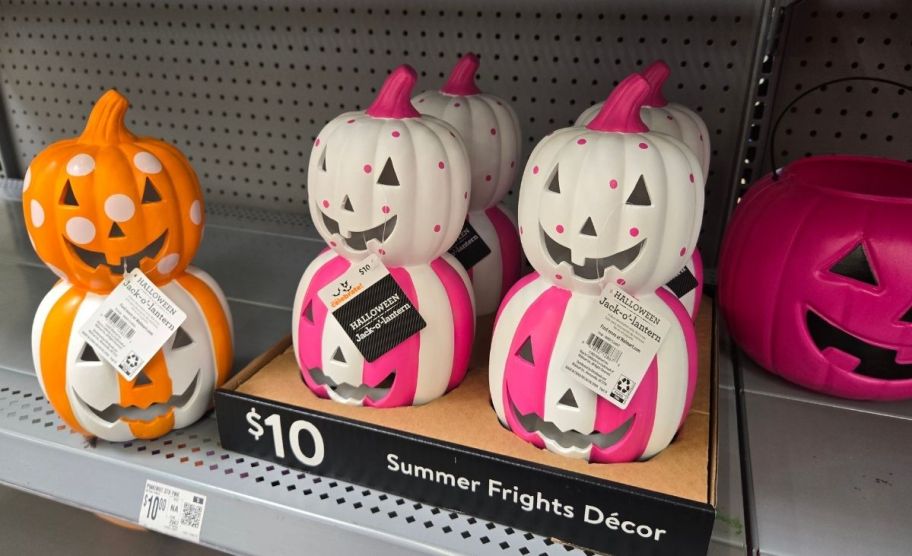 orange and white and pink and white pumpkin stacks on a store shelf