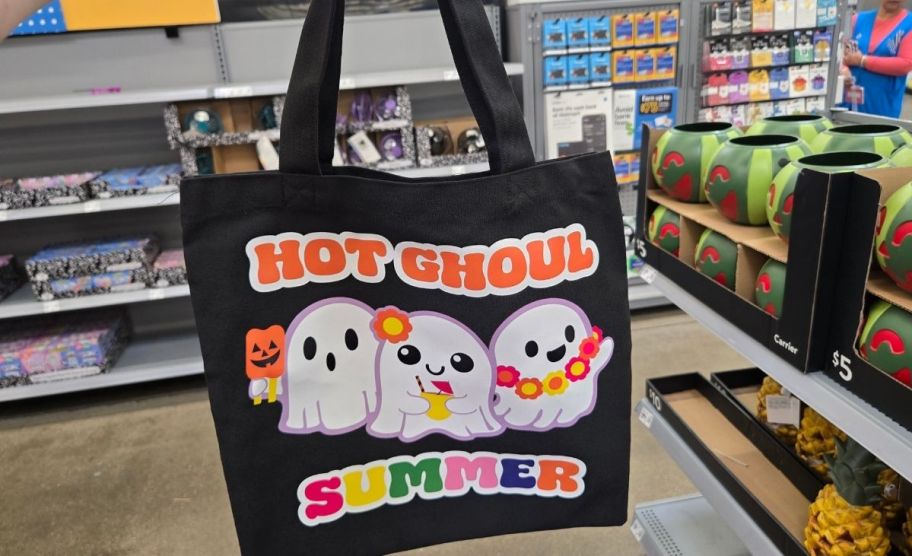 a woman's hand holding a black tote bag with ghost graphic and the words Hot ghool summer