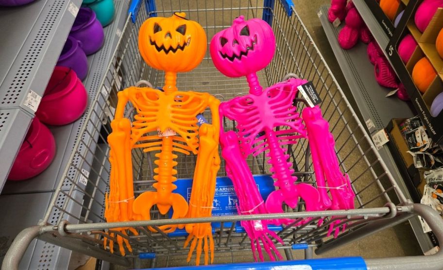 two pumpkin head skellies in a shopping cart