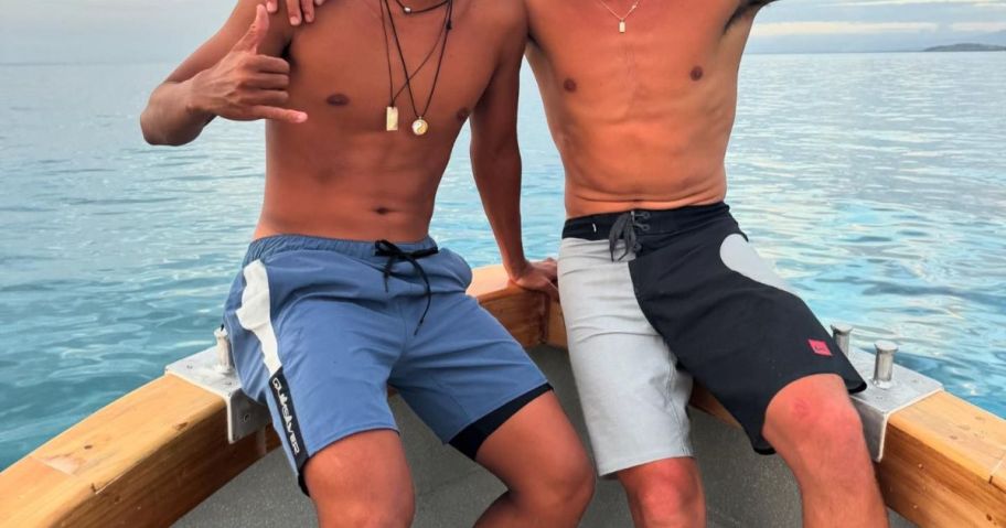 two men wearing quiksilver board shorts on boat