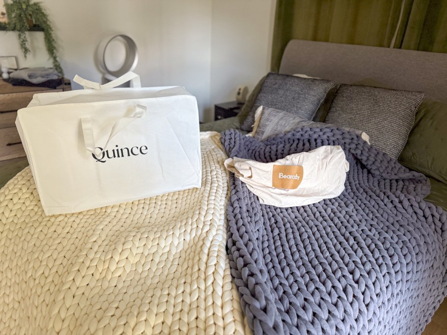 quince and bearaby knit blankets laying on bed with bags