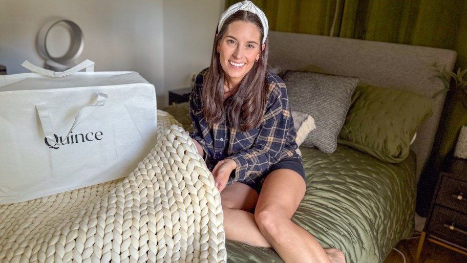 woman sitting on bed with quince bedding bag and quilt