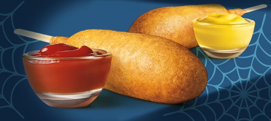 2 corndogs with a side of ketchup and mustard