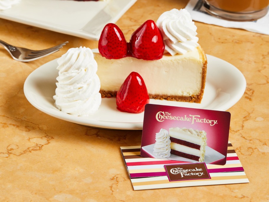 gift card next to a slice of strawberry cheesecake