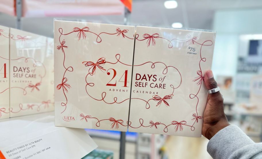 a womans hand holding an ulta advent calendar in an ulta store