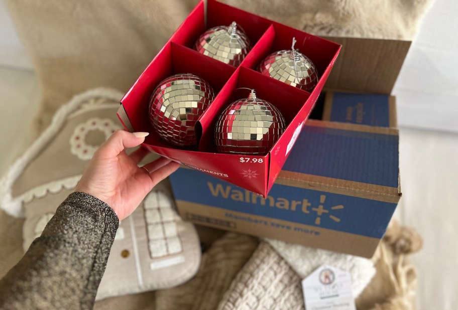 hand holding box of disco ball ornaments