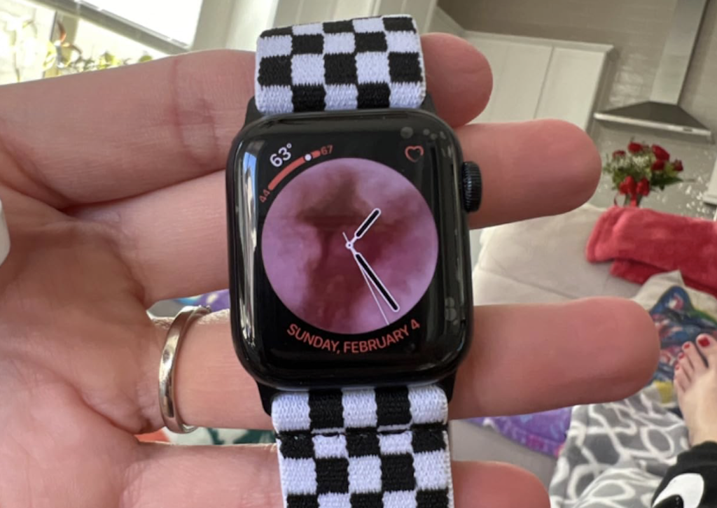 holding apple watch with checkered band 