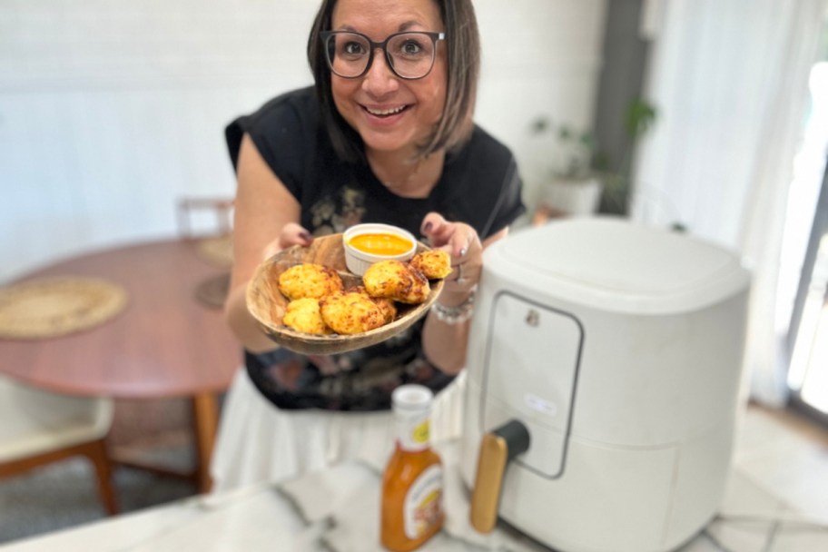 woman holding a tray of air fryer chicken nuggets 