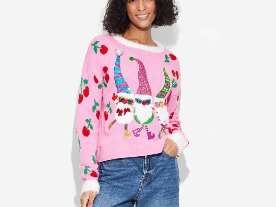 woman wearing a pink Christmas sweater with holiday gnomes on it