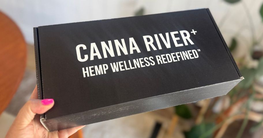 Hand holding up a box of CBD products from Canna River