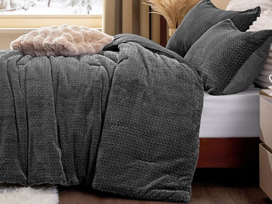 A gray comforter on a bed 