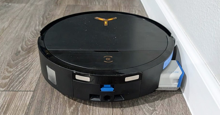 black robot vacuum cleaning along baseboards