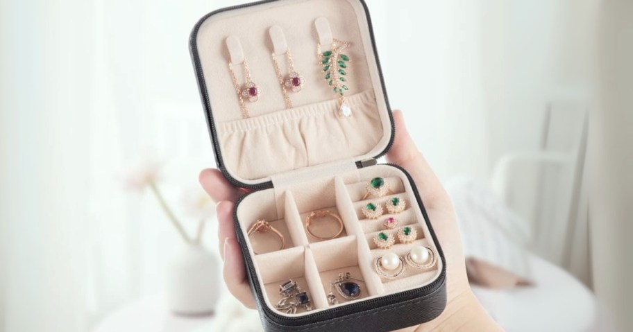 hand holding a travel jewelry case with jewelry in it