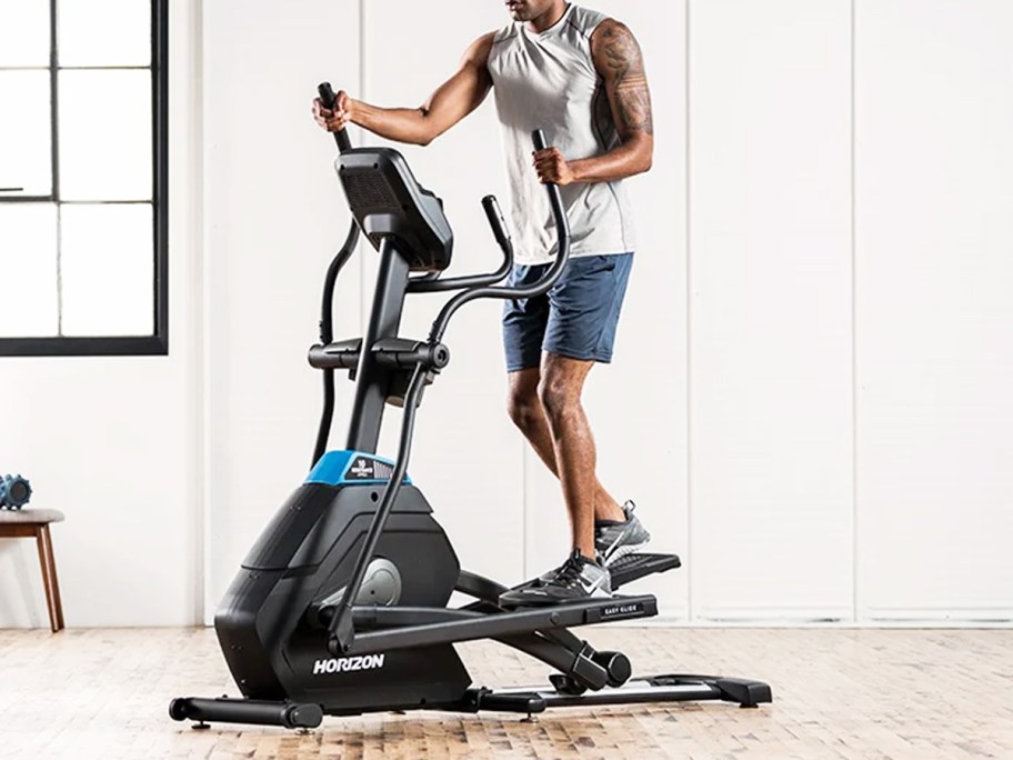 man using an elliptical machine in home