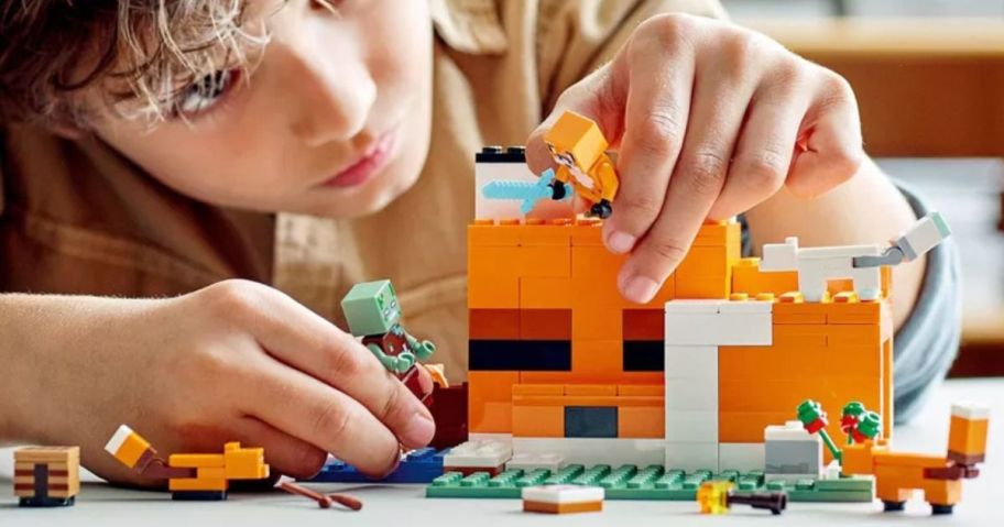 Little boy playing with a LEGO Minecraft Overworld Adventures 3-in-1 Building Set