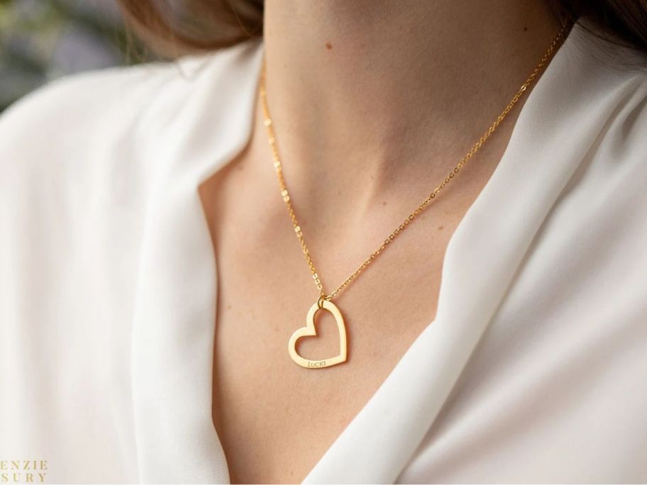A woman wearing an engraved heart necklace
