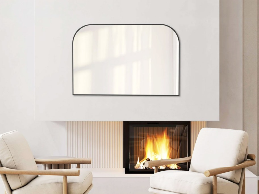 black wall mirror over mantel and fireplace