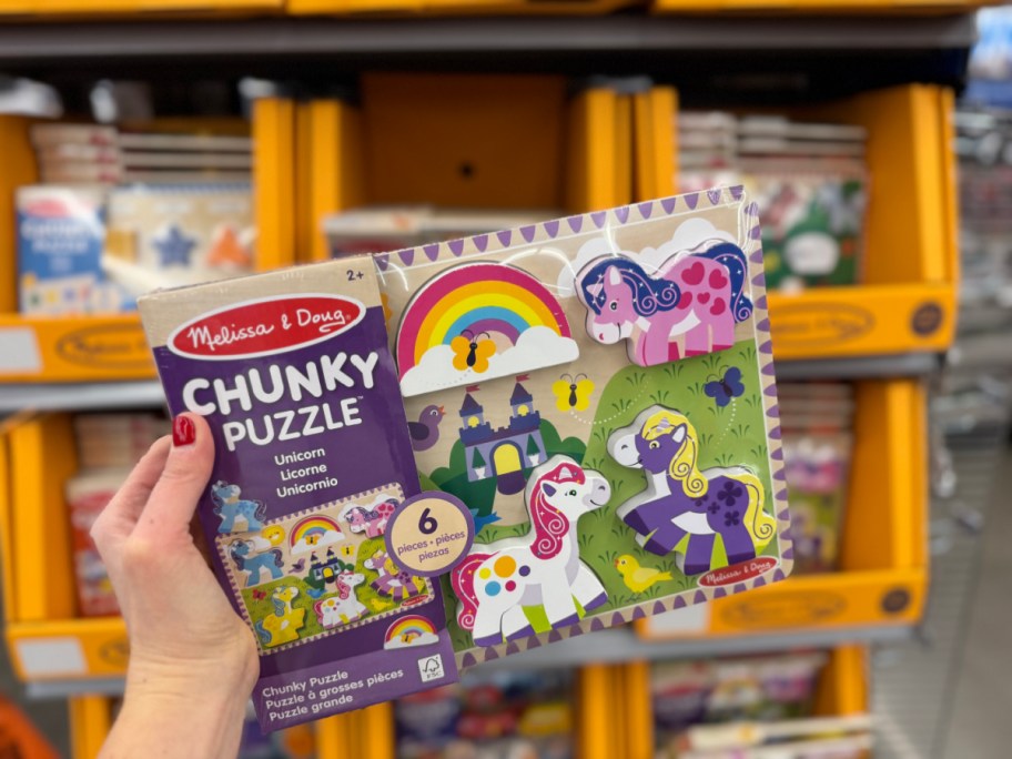 person holding up Melissa & Doug Unicorn Puzzle at walmart