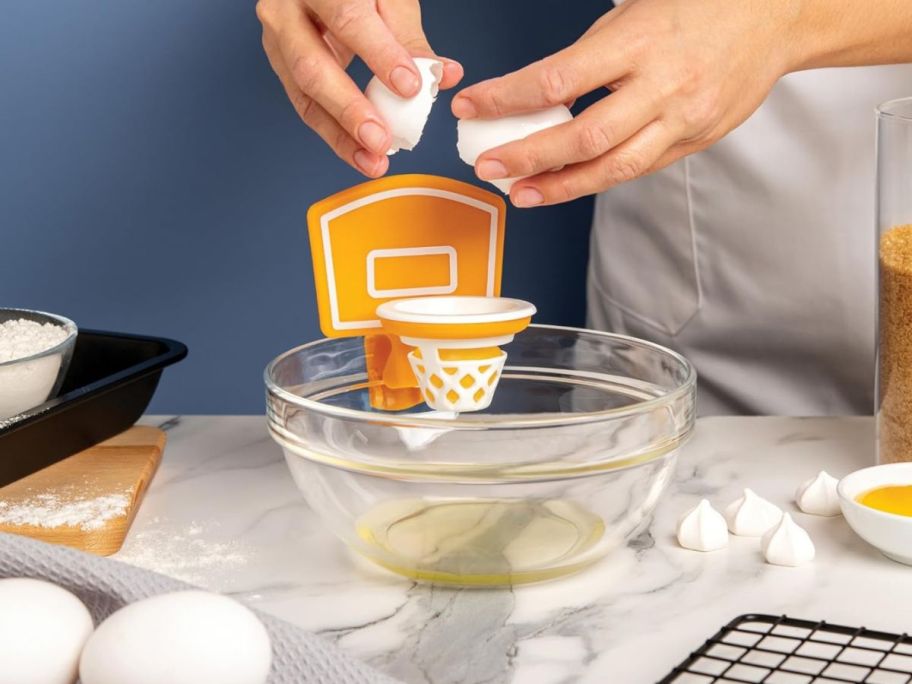 person cracking egg into OTOTO Dunk N' Egg Yolk Separator