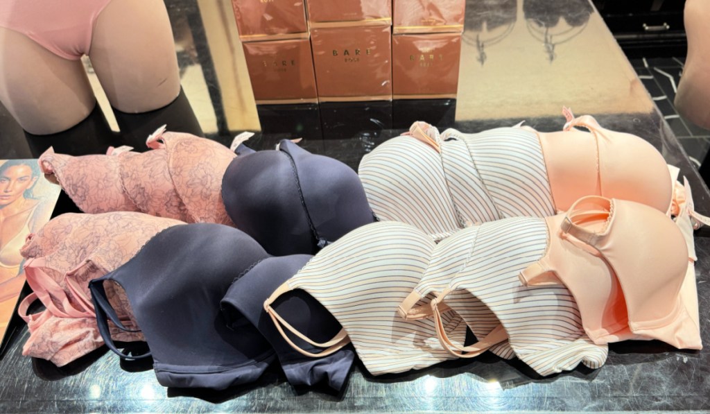 Different colored Victoria's Secret bras on black countertop in store