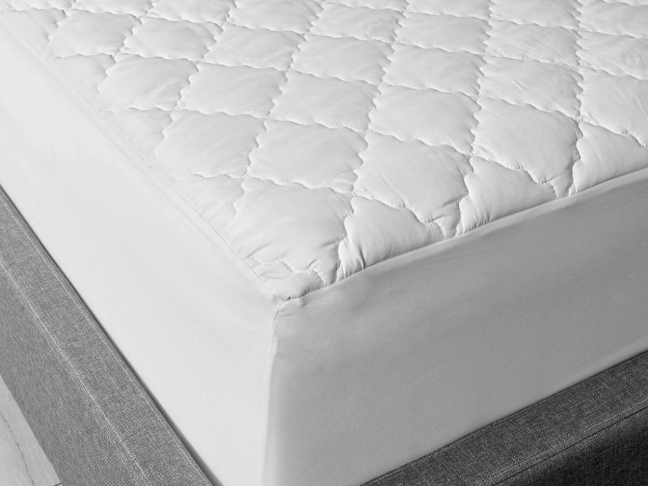 the corner of a mattress covered with a mattress topper
