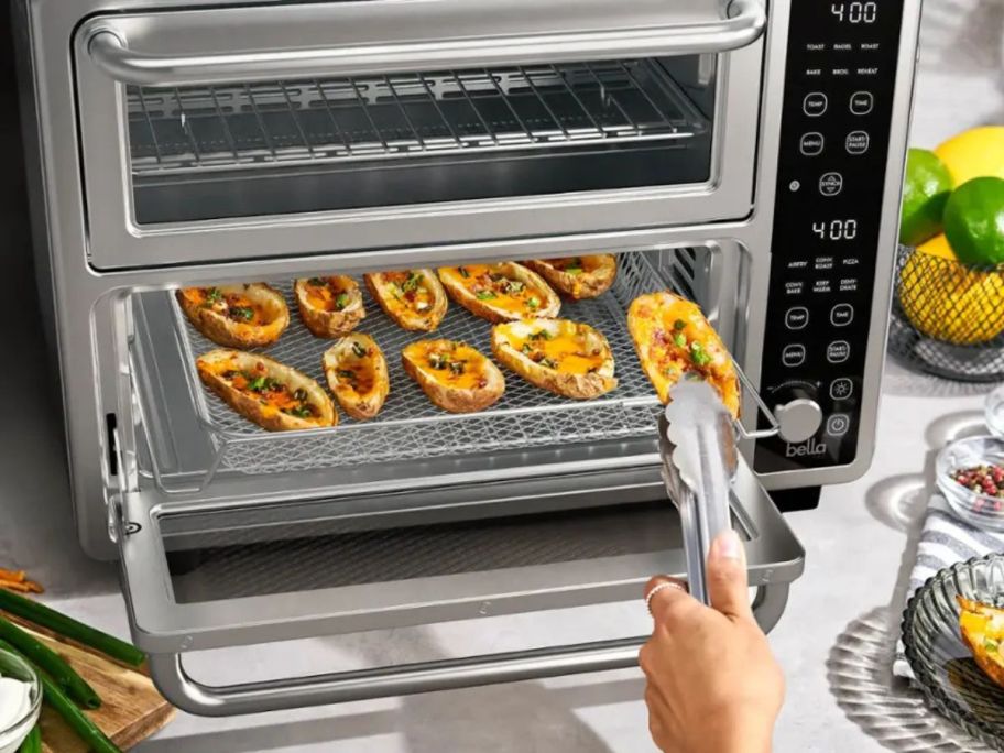 person taking potato skins out of countertop oven