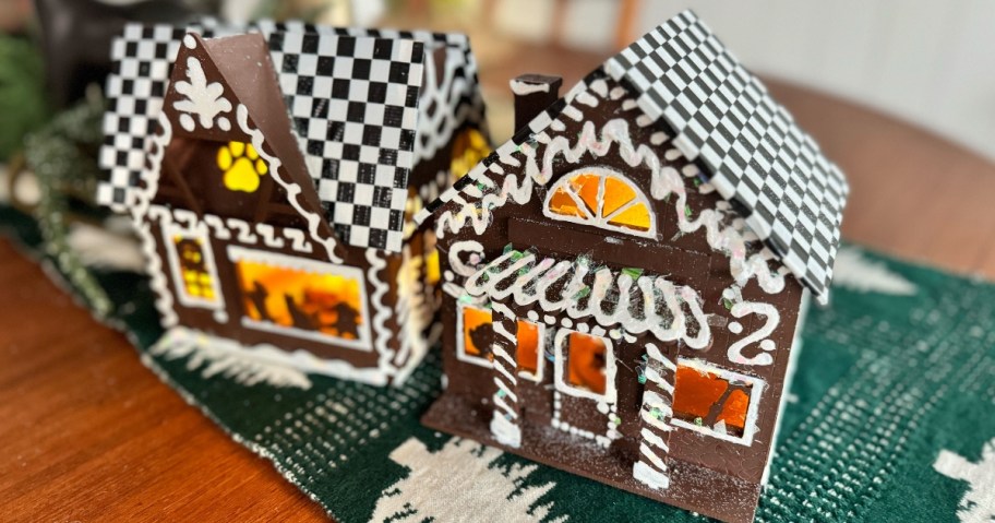 wooden craft houses that have been painted and started to be decorated with black and white duct tape and faux snow and other decor