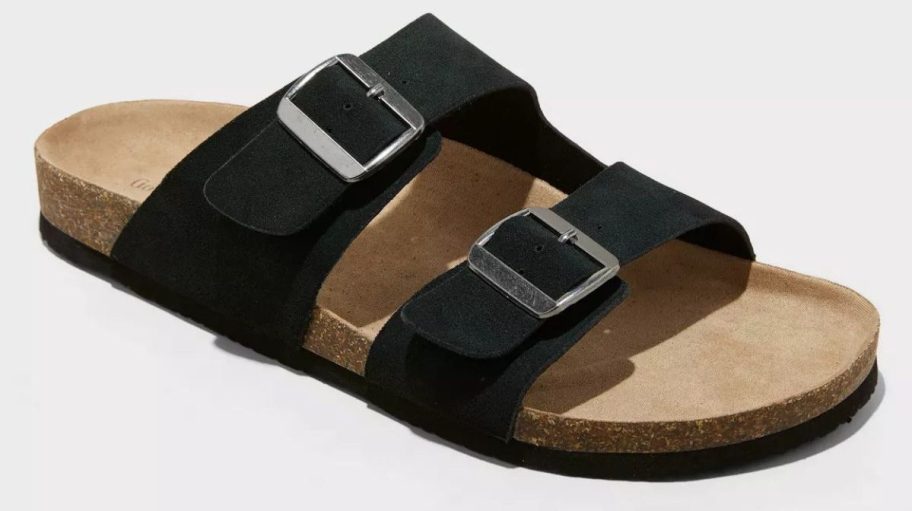Men’s black two-strap slide sandal with silver buckle accents and a cork footbed, shown on a white background.