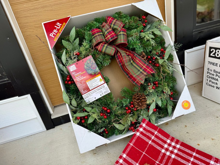 christmas wreath leaning on front door